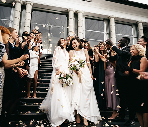 two brides walking down steps with guest around the after getting married